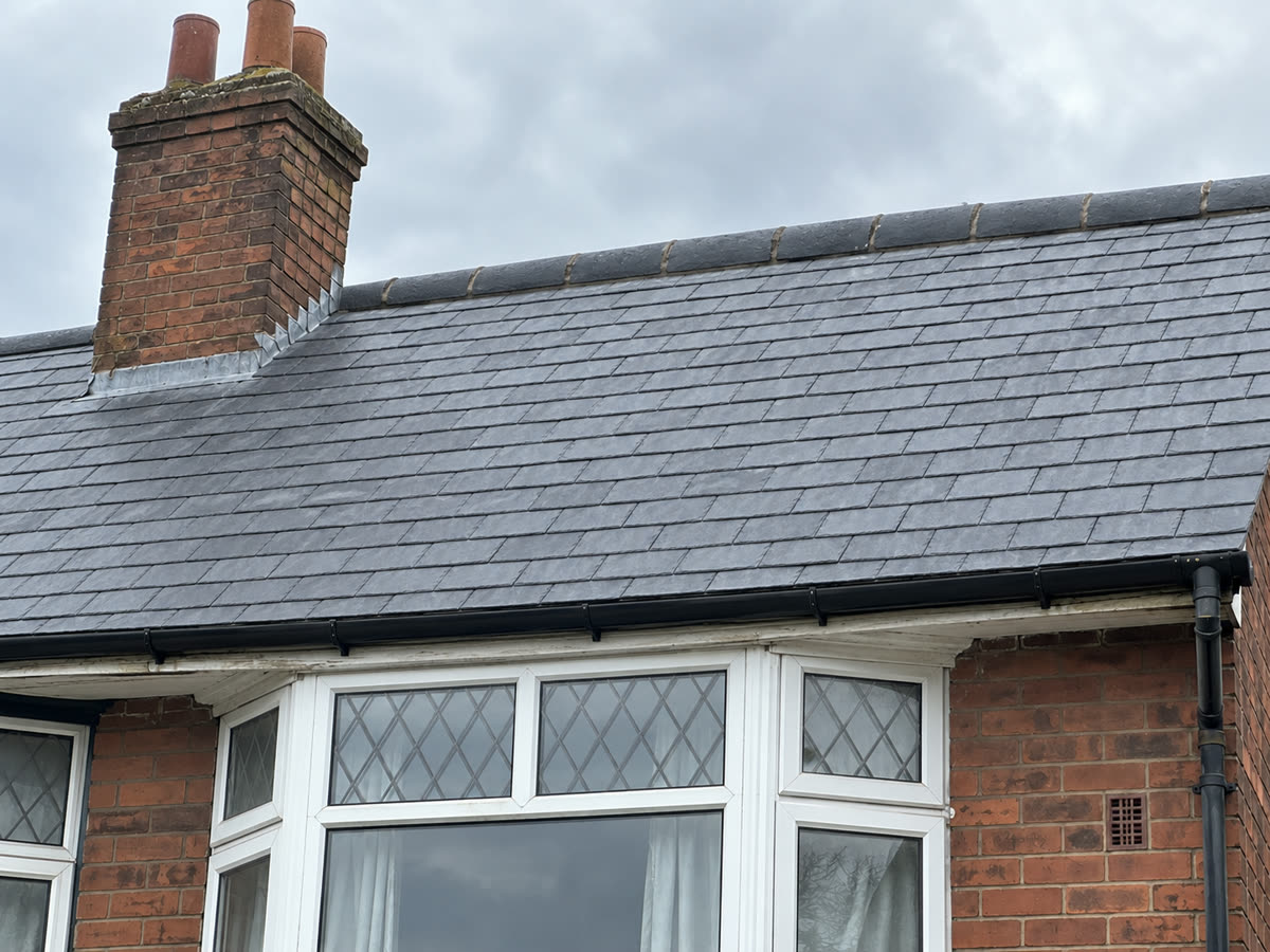 After: a new natural slate roof with new ridge tiles and gutter