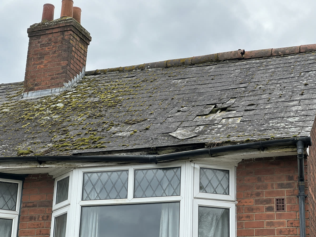 Before: an old slate roof with slipped and missing slates and moss